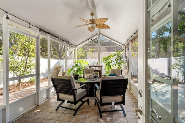 sunroom / solarium with ceiling fan, a healthy amount of sunlight, and vaulted ceiling