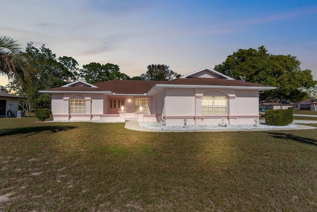 ranch-style home with a lawn