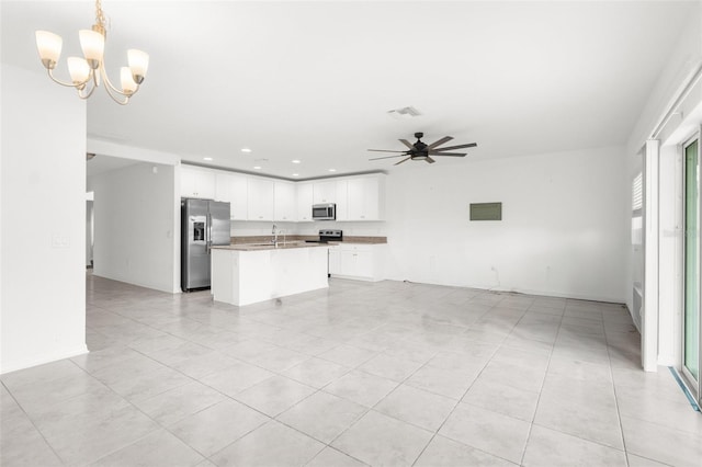 kitchen with ceiling fan with notable chandelier, stainless steel appliances, pendant lighting, white cabinetry, and an island with sink