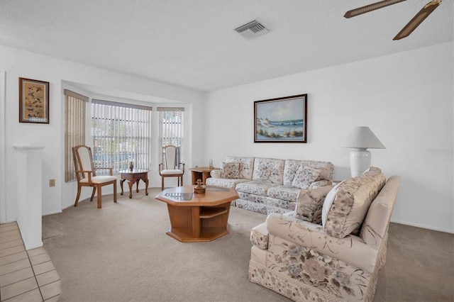 carpeted living room with ceiling fan and a textured ceiling