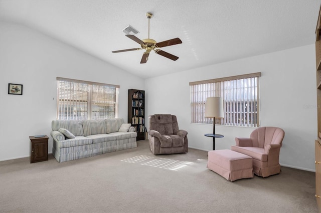 living room with ceiling fan, plenty of natural light, light carpet, and lofted ceiling