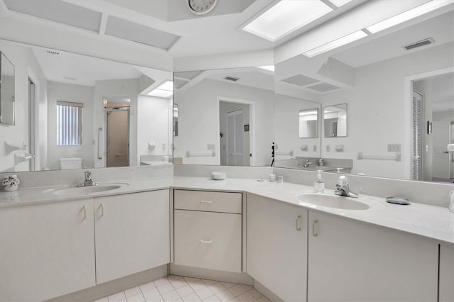 bathroom with tile patterned floors, a shower with door, vanity, and toilet