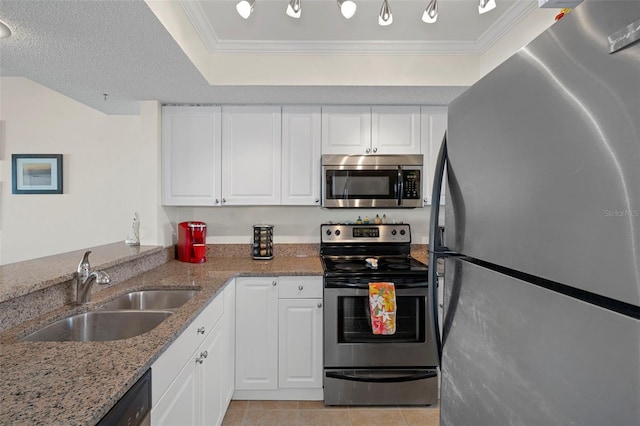 kitchen with light stone countertops, appliances with stainless steel finishes, sink, light tile patterned floors, and white cabinetry