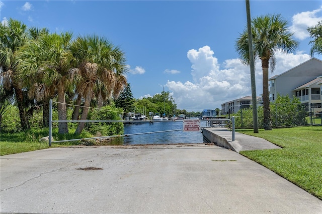 surrounding community featuring a lawn and a water view