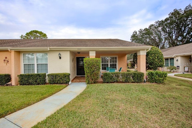 ranch-style home featuring a front yard and stucco siding