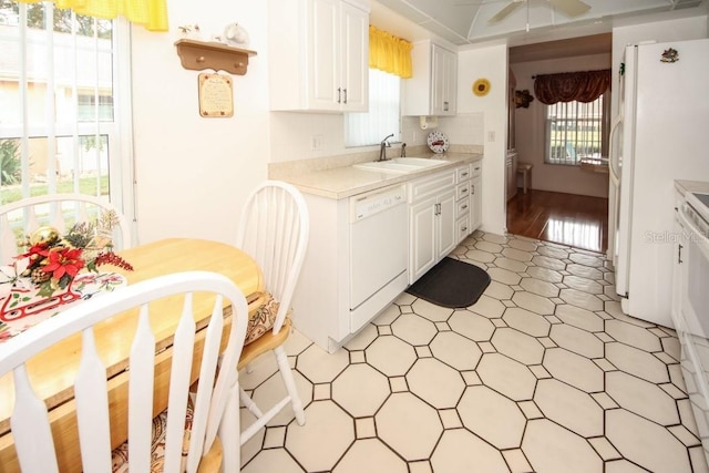 kitchen featuring light countertops, a ceiling fan, white cabinetry, a sink, and white appliances