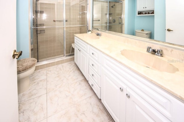 bathroom featuring double vanity, a sink, toilet, and a shower stall