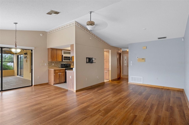 unfurnished living room featuring a textured ceiling, hardwood / wood-style flooring, ceiling fan, and lofted ceiling