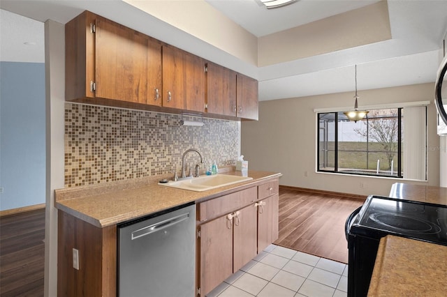 kitchen featuring backsplash, sink, dishwasher, hanging light fixtures, and light tile patterned flooring