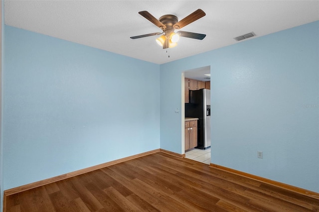 empty room featuring ceiling fan and light hardwood / wood-style flooring