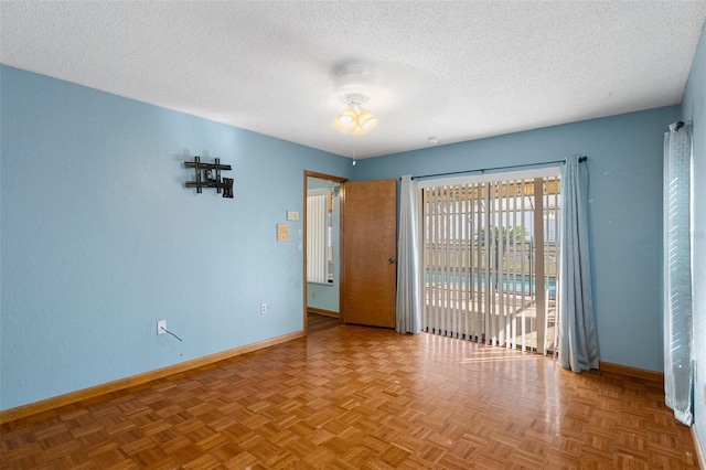 empty room with parquet floors and a textured ceiling