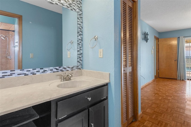 bathroom featuring vanity, parquet flooring, and a textured ceiling