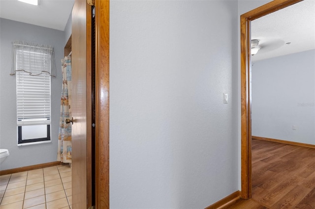 corridor featuring light tile patterned floors and a textured ceiling