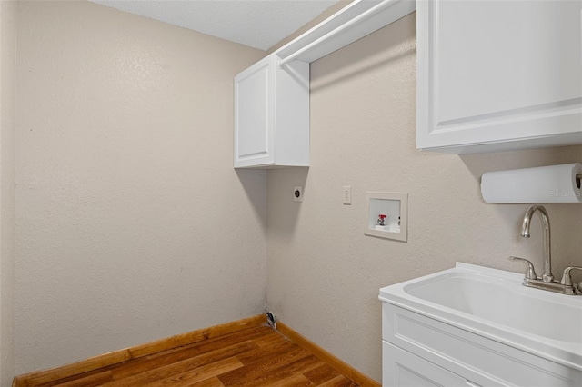 laundry room with sink, cabinets, hookup for an electric dryer, hookup for a washing machine, and hardwood / wood-style flooring