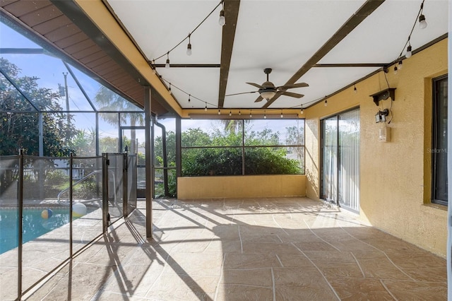 unfurnished sunroom with ceiling fan