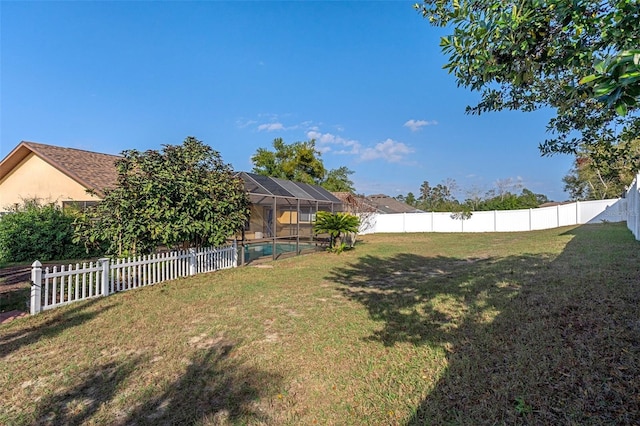 view of yard with a fenced in pool and glass enclosure