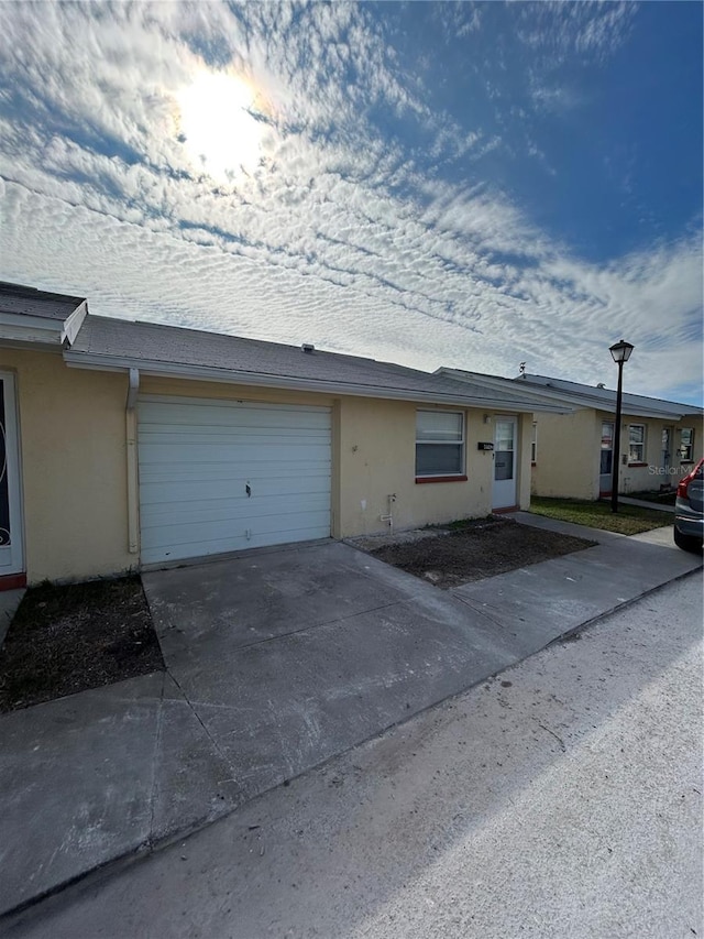 view of front of property with a garage, driveway, and stucco siding