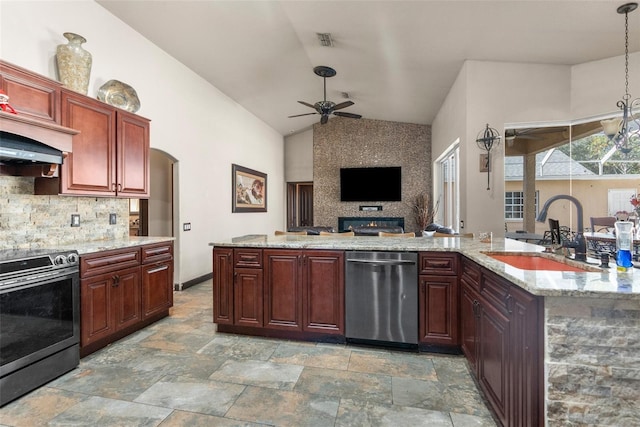 14101 Andrew Scott Rd, Spring Hill, FL 34609 - kitchen featuring appliances with stainless steel finishes, a ceiling fan, lofted ceiling, stone tile flooring, and tasteful backsplash