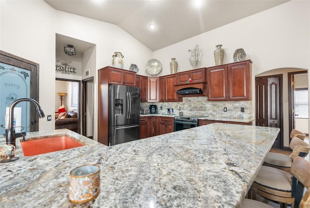14101 Andrew Scott Rd, Spring Hill, FL 34609 - kitchen featuring appliances with stainless steel finishes, range hood, a kitchen bar, light stone countertops, and decorative backsplash