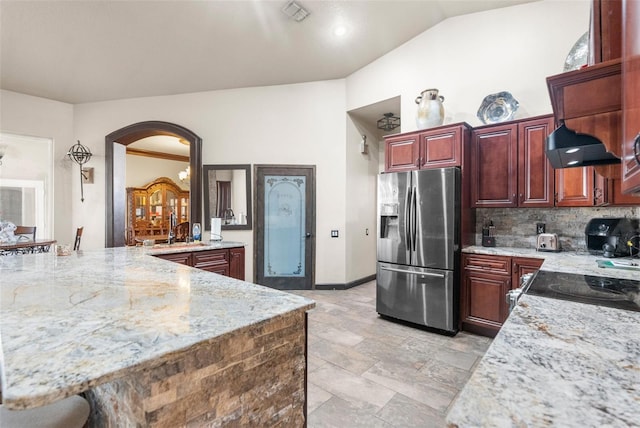 14101 Andrew Scott Rd, Spring Hill, FL 34609 - kitchen featuring stainless steel refrigerator with ice dispenser, arched walkways, lofted ceiling, light stone counters, and decorative backsplash