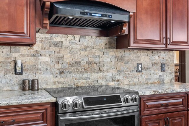 14101 Andrew Scott Rd, Spring Hill, FL 34609 - kitchen with electric stove, custom range hood, decorative backsplash, dark brown cabinets, and light stone counters