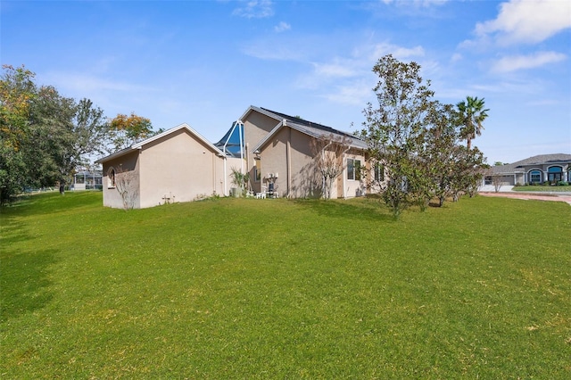 14101 Andrew Scott Rd, Spring Hill, FL 34609 - view of side of property with a lawn and stucco siding