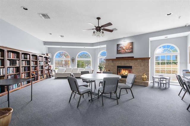 14101 Andrew Scott Rd, Spring Hill, FL 34609 - dining room featuring carpet floors, ceiling fan, a fireplace, healthy amount of natural light, and a textured ceiling
