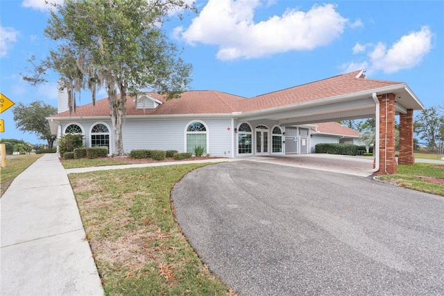 14101 Andrew Scott Rd, Spring Hill, FL 34609 - view of front of house featuring asphalt driveway, french doors, a front yard, and a chimney