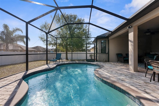 view of pool featuring a lanai, ceiling fan, and a patio