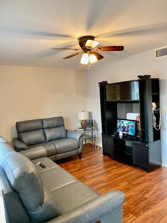 living room with wood-type flooring and ceiling fan