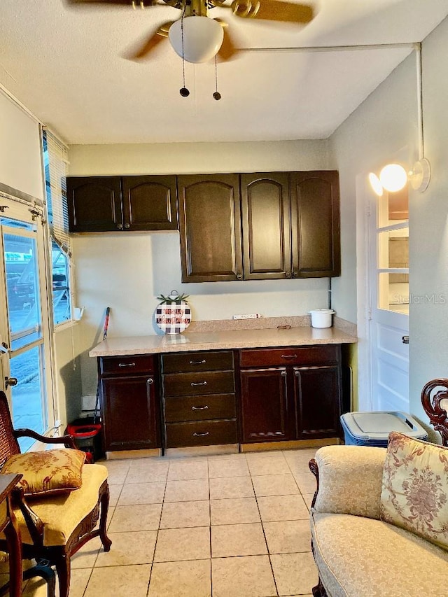 kitchen with ceiling fan, dark brown cabinets, and light tile patterned floors