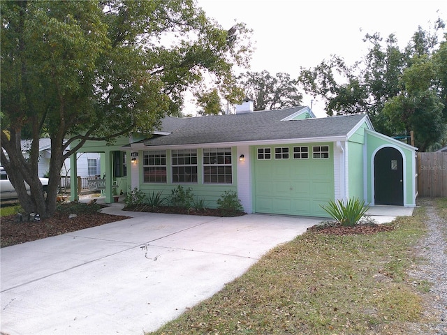 single story home with a garage, a shingled roof, a chimney, and concrete driveway