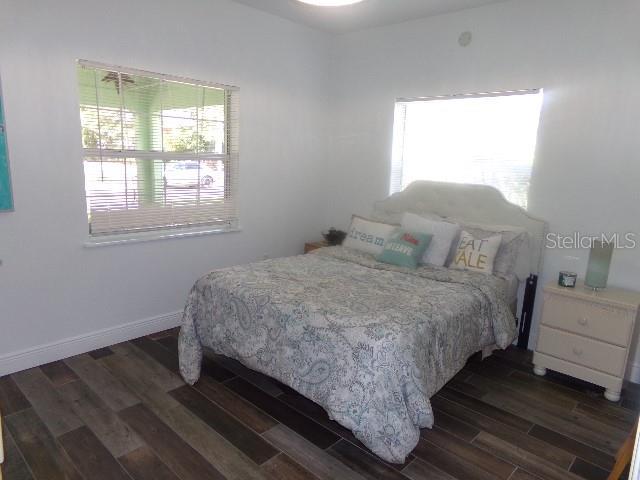 bedroom featuring dark wood-type flooring and baseboards