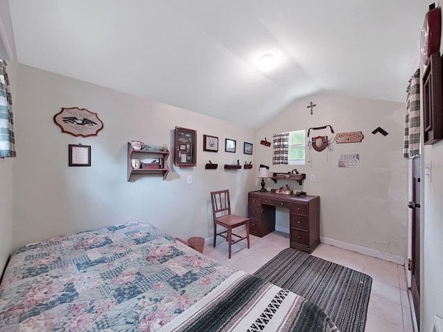 bedroom with lofted ceiling, baseboards, and light tile patterned floors