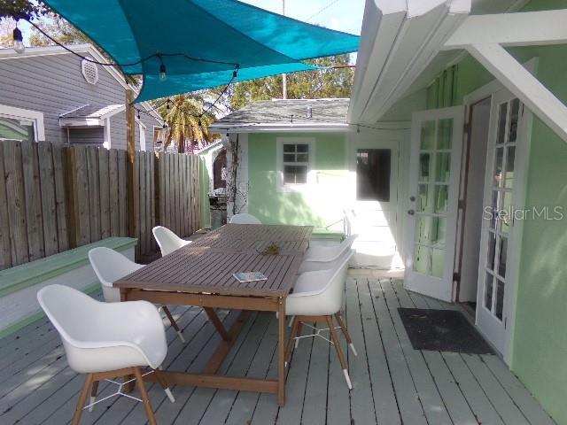 deck with outdoor dining area and fence