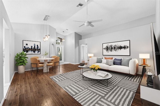 living room with ceiling fan, dark hardwood / wood-style floors, and vaulted ceiling