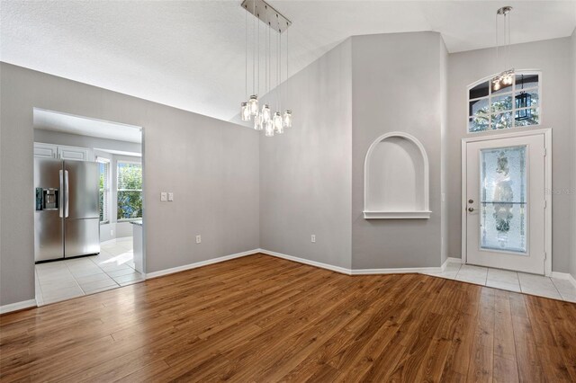 foyer entrance featuring light wood-type flooring and a notable chandelier