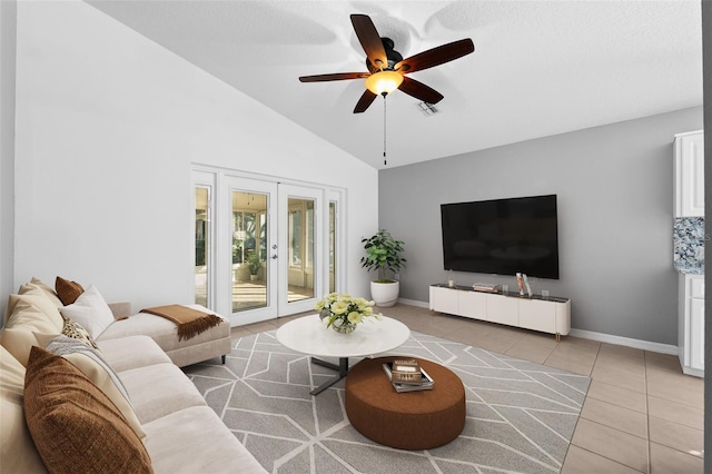 tiled living room with ceiling fan, french doors, and high vaulted ceiling