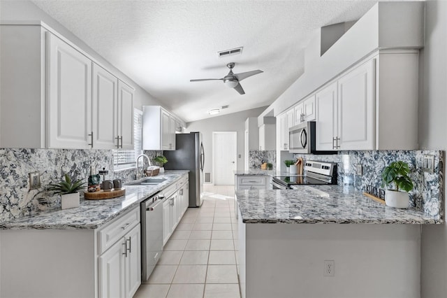 kitchen with kitchen peninsula, white cabinetry, and appliances with stainless steel finishes