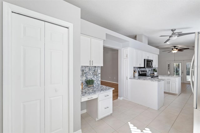 kitchen featuring backsplash, white cabinetry, light tile patterned floors, and appliances with stainless steel finishes