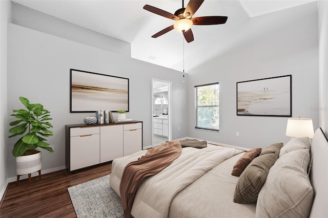 bedroom with ceiling fan, dark hardwood / wood-style flooring, lofted ceiling, and ensuite bath