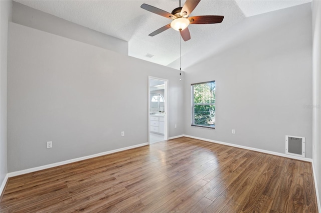 empty room with ceiling fan, high vaulted ceiling, a textured ceiling, and hardwood / wood-style flooring