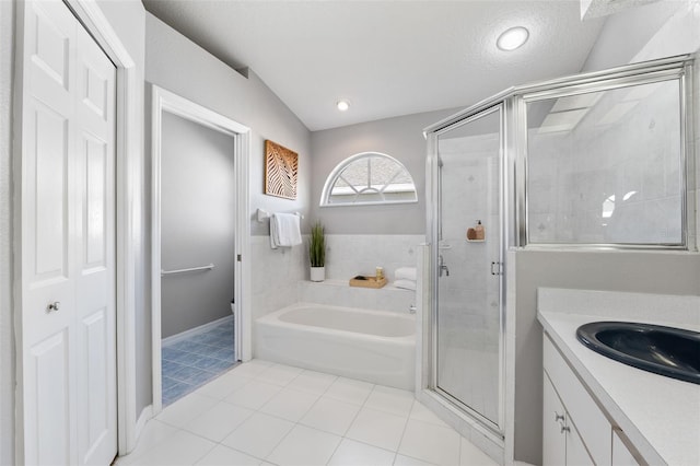 bathroom featuring tile patterned floors, vanity, a textured ceiling, and plus walk in shower