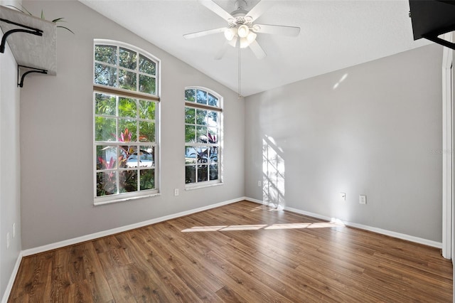 empty room with ceiling fan, lofted ceiling, and hardwood / wood-style flooring