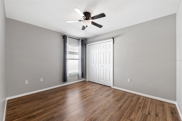 unfurnished bedroom featuring ceiling fan, a closet, wood-type flooring, and a textured ceiling