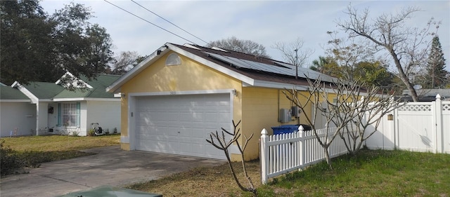 view of property exterior featuring a yard, a garage, and solar panels