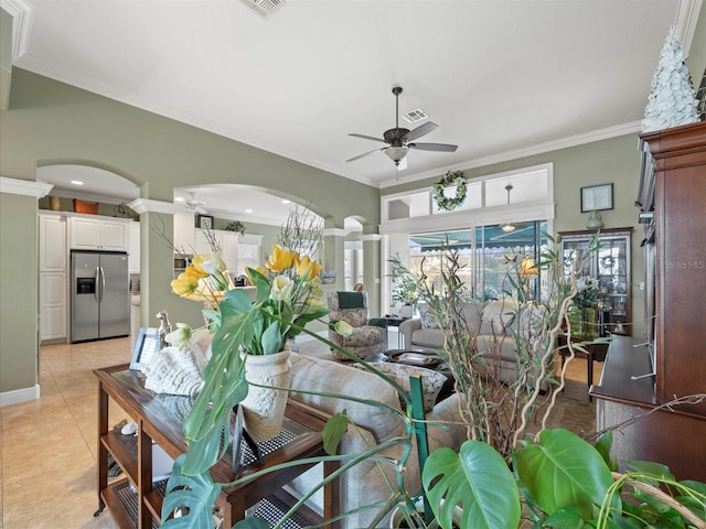 tiled living room with ceiling fan and crown molding