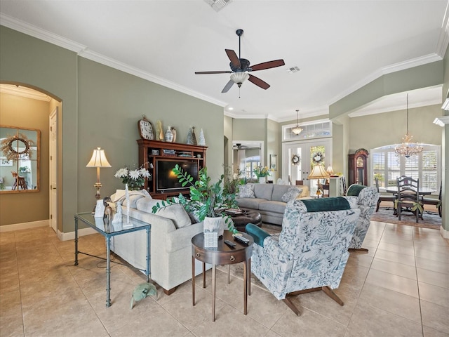 tiled living room with french doors, ceiling fan with notable chandelier, and ornamental molding