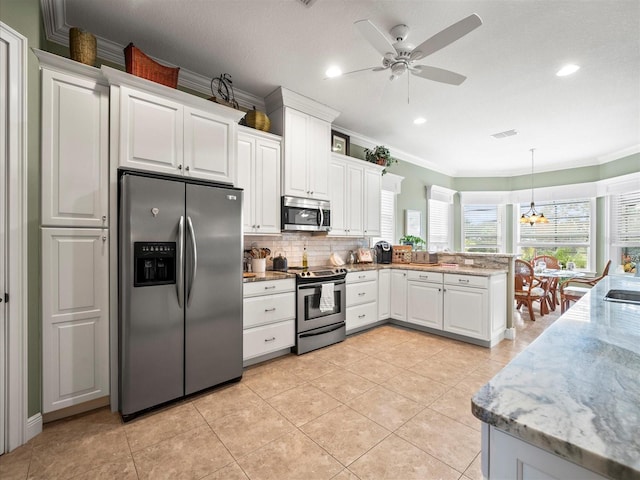 kitchen with white cabinetry, light stone counters, pendant lighting, ceiling fan with notable chandelier, and appliances with stainless steel finishes