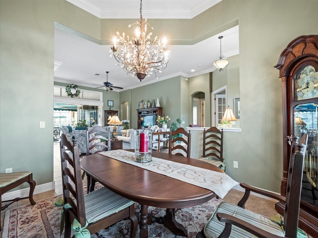 tiled dining room with ceiling fan with notable chandelier and ornamental molding